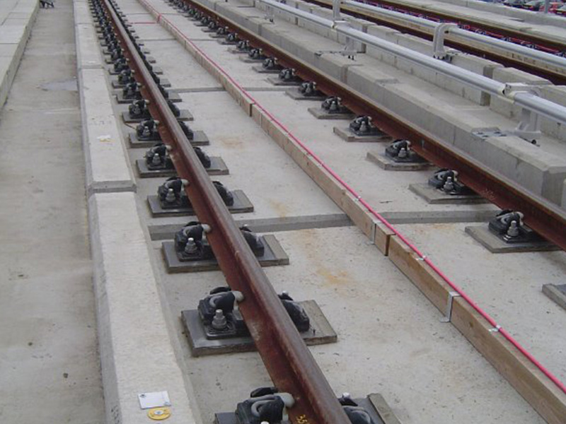 Rail fixings to fibre reinforced concrete trackslab