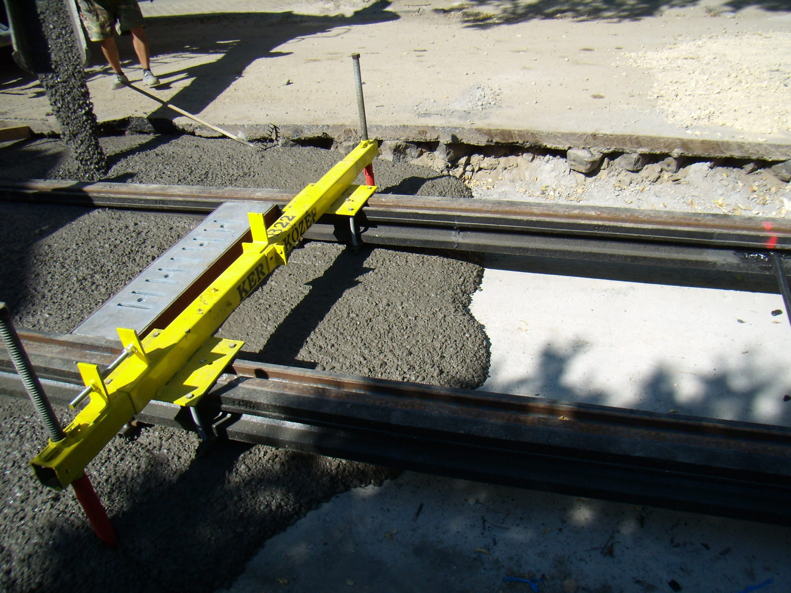 Fibre reinforced concrete tram line being poured around preinstalled rail system.