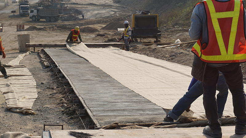 burlap sack being placed on concrete for curing.