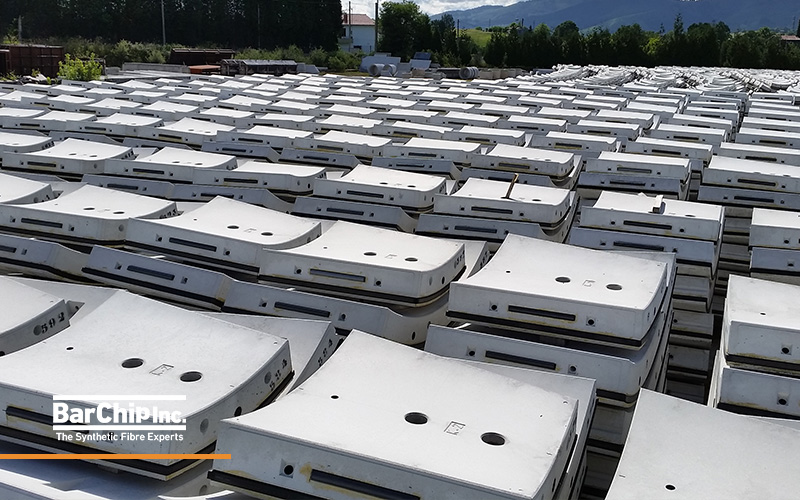 Completed precast tunnel segments stacked in storage yard.